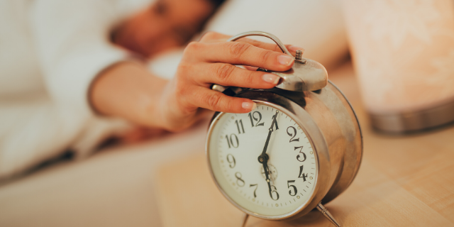 Mulher desligando o despertador