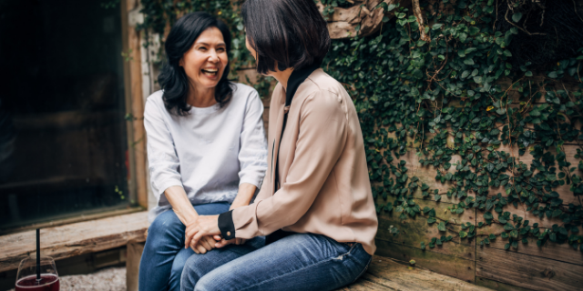 Duas amigas sorrindo juntas e conversando