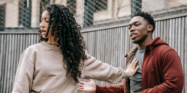 Mulher brigando com homem o afastando com a mão