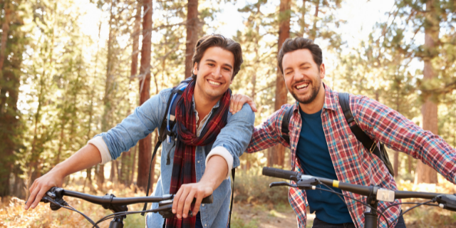 Casal sorrindo andando de bicicleta juntos