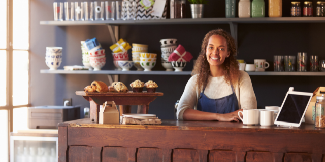 Vendedora sorrindo em sua loja