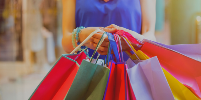 Mulher segurando várias sacolas de compras