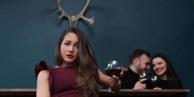 Mulher triste enquanto está sendo traída