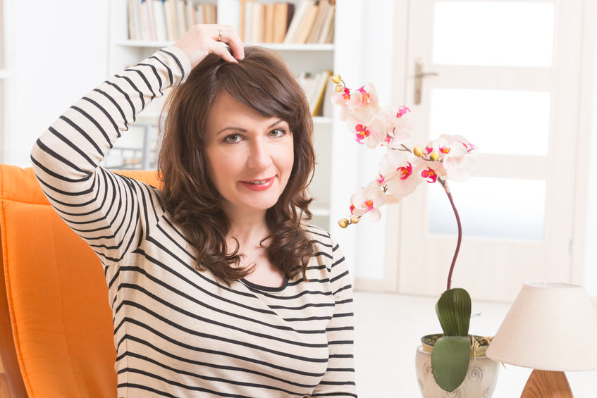 Mulher tocando topo de sua cabeça