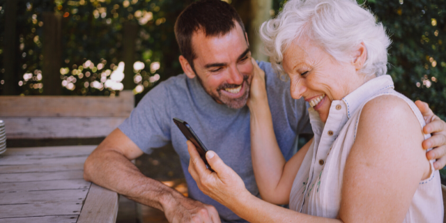 Neto feliz ajudando avó a mexer no celular