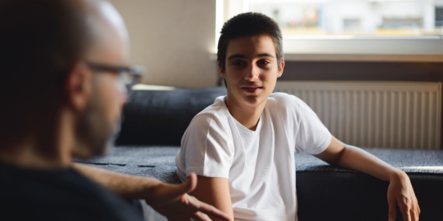 Pai e filho conversando na sala