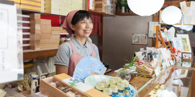 Vendedora sorrindo em sua loja vendendo algo