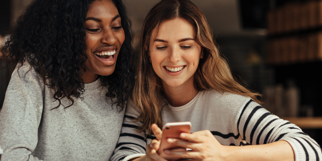 Casal sorrindo olhando para o telefone