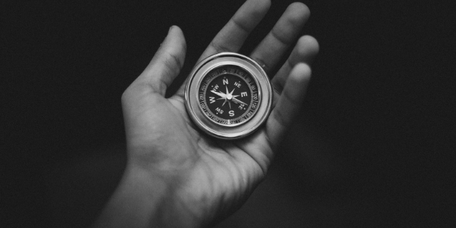 Uma mão segurando uma bússula