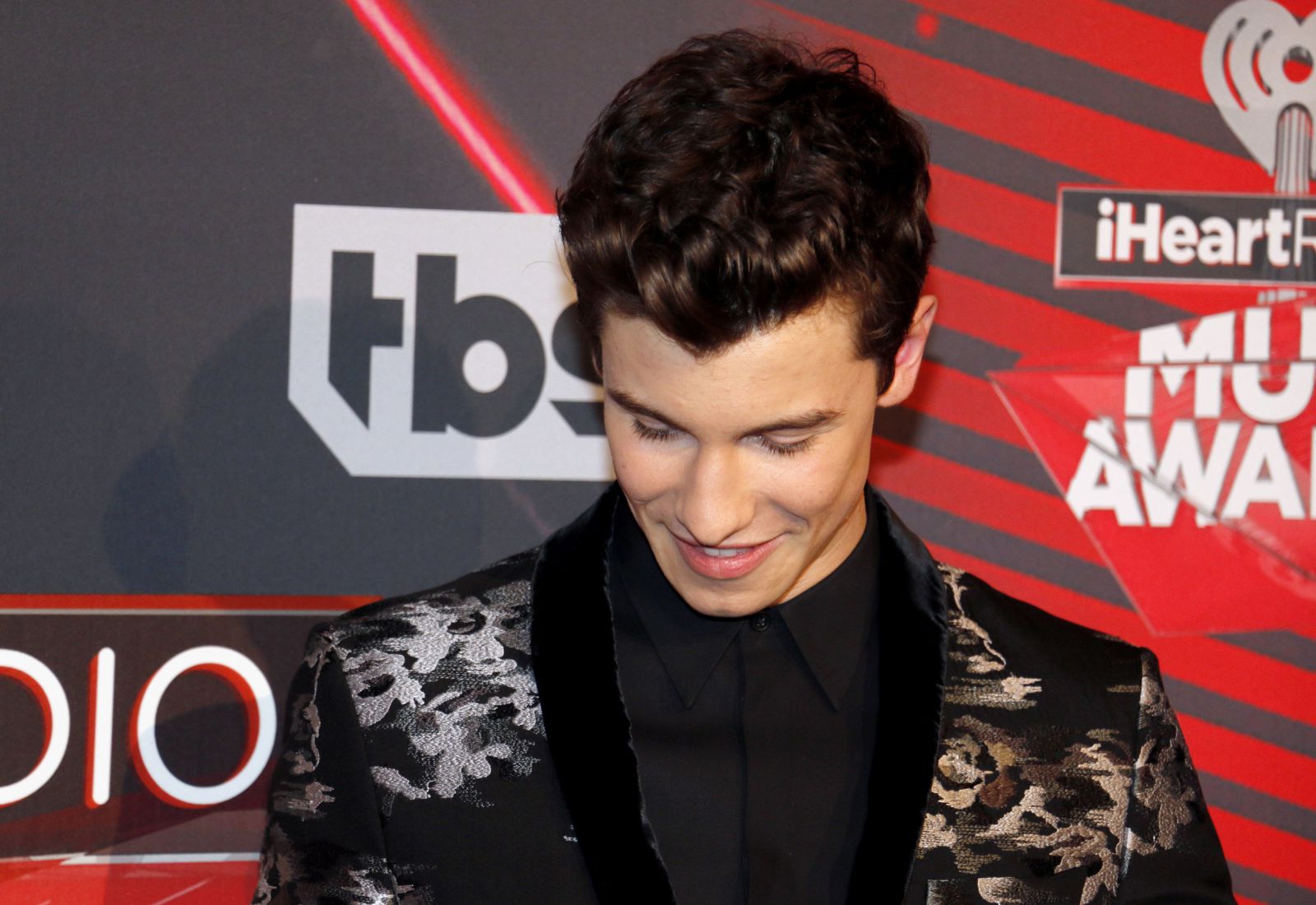 Shawn Mendes em premiação olhando para baixo e sorrindo
