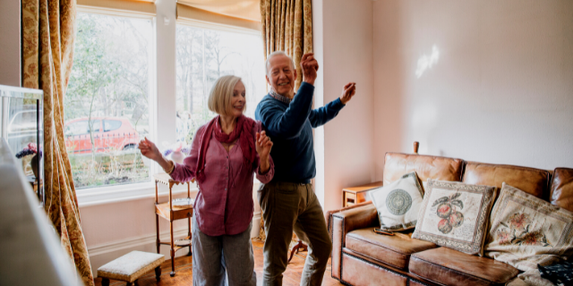 Casal de idosos felizes dançando na sala