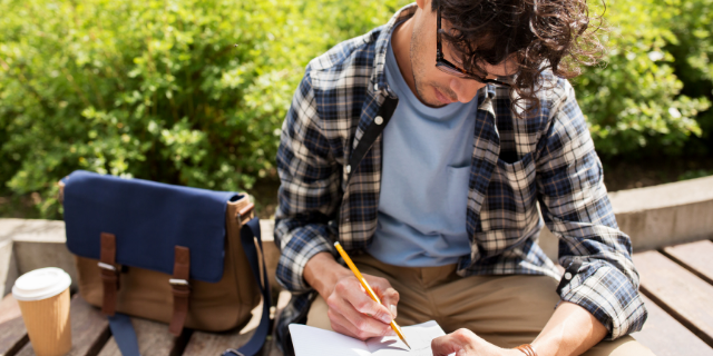 Escritor sentado escrevendo em seu caderno