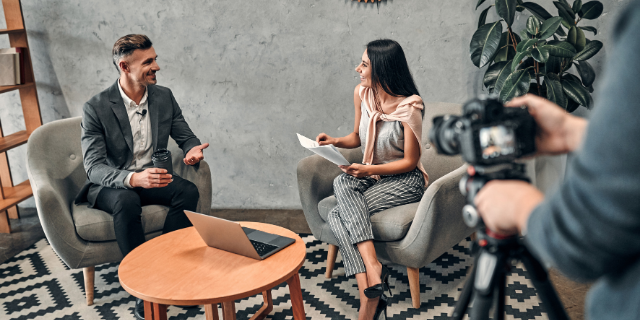 Jornalista simpática entrevistando um convidado
