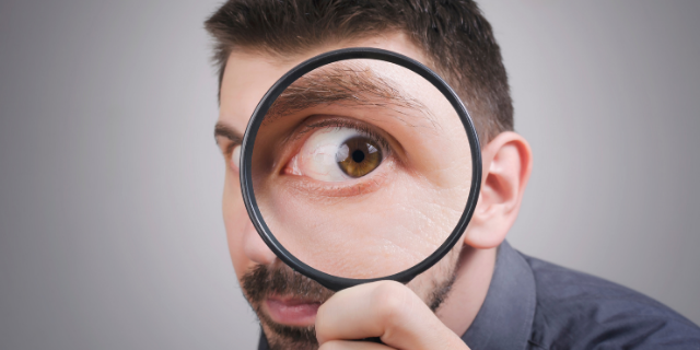 Homem com lupa no olho direito. 