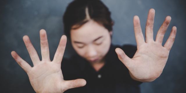 Homem com as mãos erguidas sobre o rosto.
