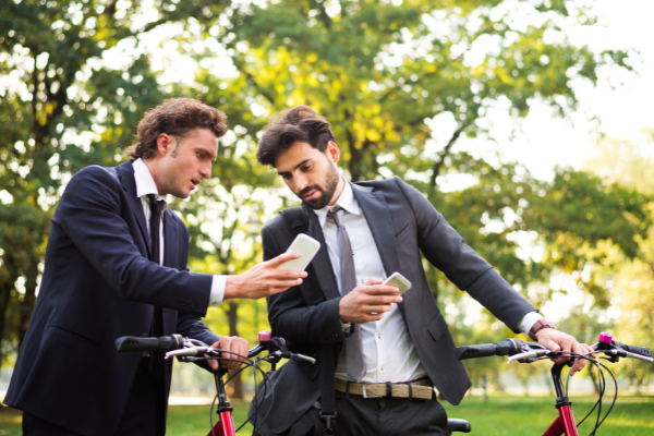 Dois homens olhando algo no celular e comentando entre eles