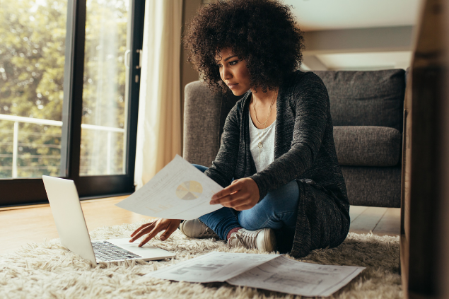 Mulher sentada em um tapete trabalhando no computador