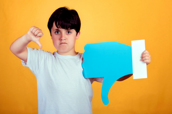 Menino com raiva fazendo um sinal negativo com a mão direita