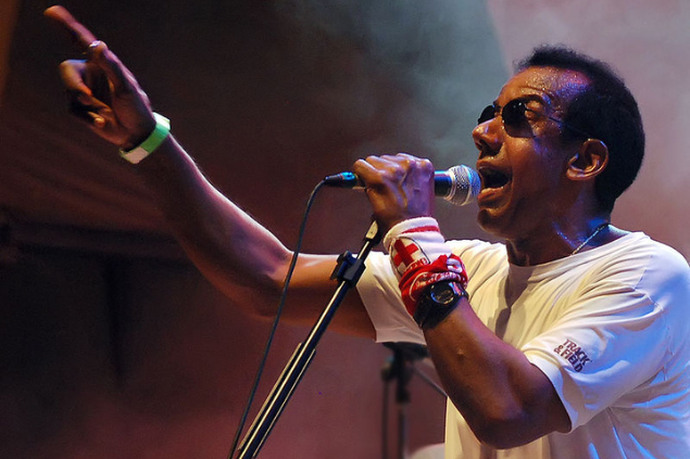 Jorge Ben Jor cantando e apontando para cima com o braço direito