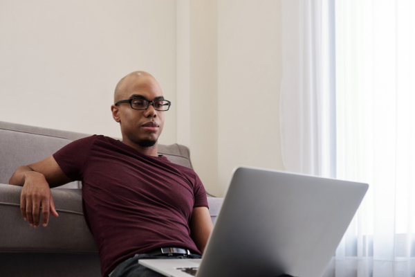 Homem sentado assistindo a uma série em seu notebook