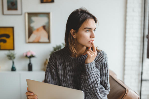 Mulher sentada com a cabeça virada à esquerda olhando fixamente para um ponto 