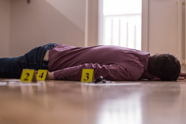 Corpo morto com placas de sinalização da pericia. 