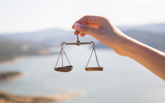 Uma mão segurando uma balança em equilíbrio