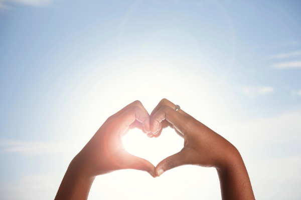 Mulher formando um coração com as mãos