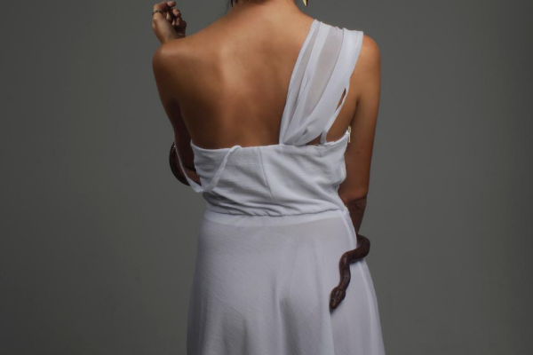 Mulher usando vestido com uma cobra enrolando em seu corpo
