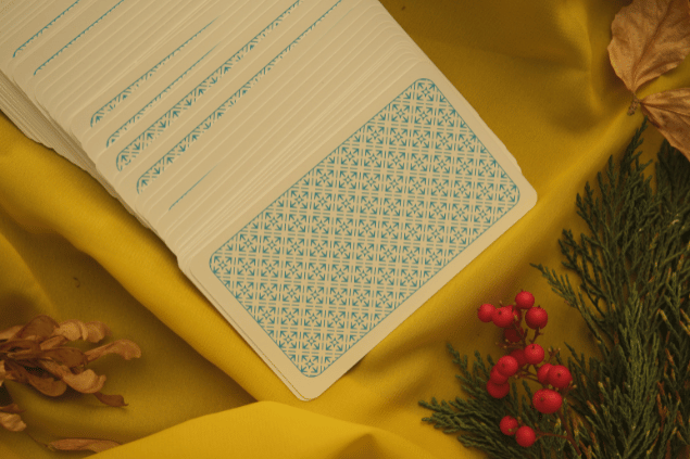 Algumas cartas de Tarot viradas para baixo estão em destaque na imagem. Ao lado, há plantas.