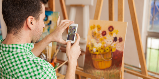 Homem tirando foto de quadro