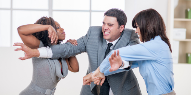 Homem separando duas mulheres que estão brigando