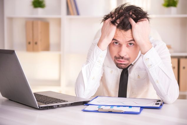 Imagem de um homem na frente de seu notebook com semblante de preocupação