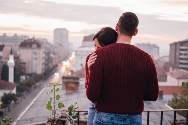 Imagem de um casal abraçado em uma varanda