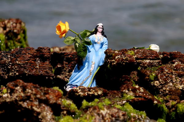 Escultura de Iemanjá em pedras na praia.