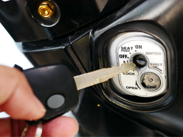 Pessoa colocando chave em ignição de moto