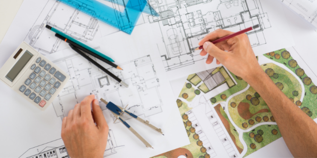 Homem trabalha em projeto arquitetônico. 