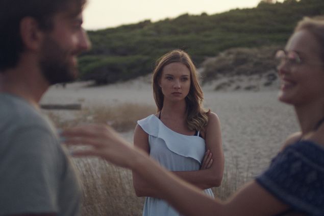 Imagem de uma mulher olhando com ciúmes para um casal
