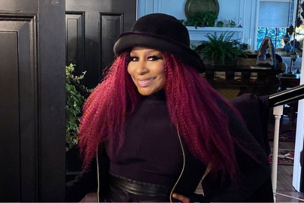 Cantora Chaka Khan de cabelos vermelhos e chapéu preto.