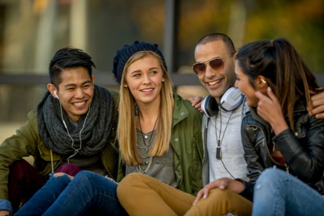 Imagem de 4 amigos conversando e sorrindo