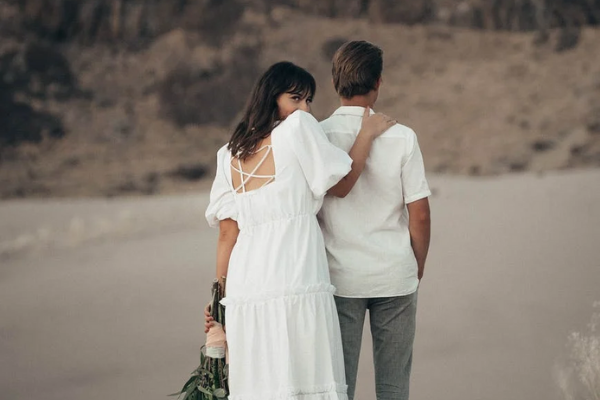 Mulher e homem brancos na praia.