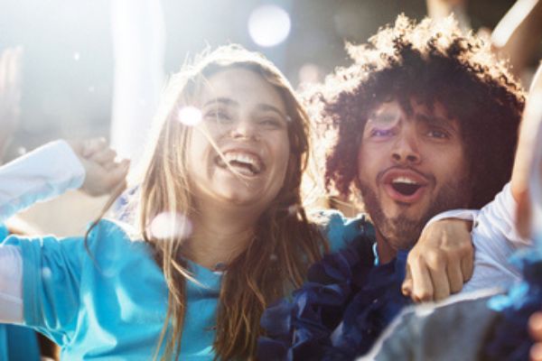 Casal feliz no meio de uma multidão de pessoas