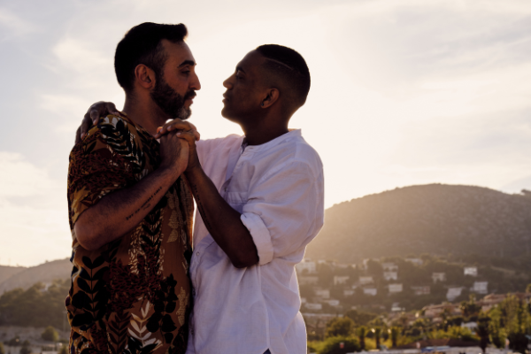 Dois homens de mãos dadas, olhando um no olho do outro