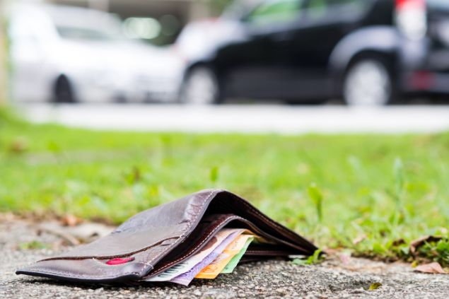 carteira cheia de dinheiro no chão da rua