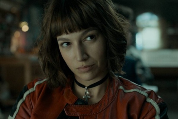 Tóquio olhando para o lado usando franjinha e colar 