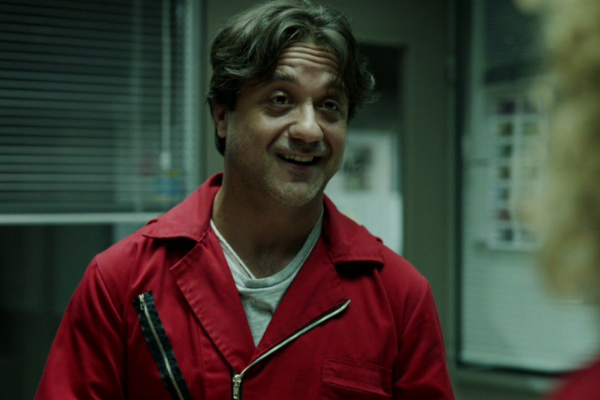 Arturo sorrindo olhando para frente em um escritório 