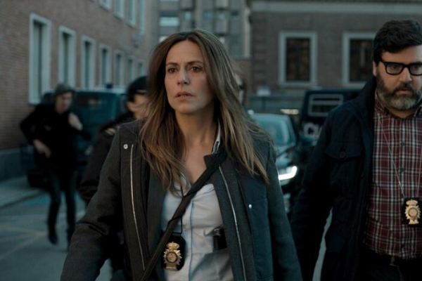 Inspetora Murillo andando na rua ao lado de outro policial 