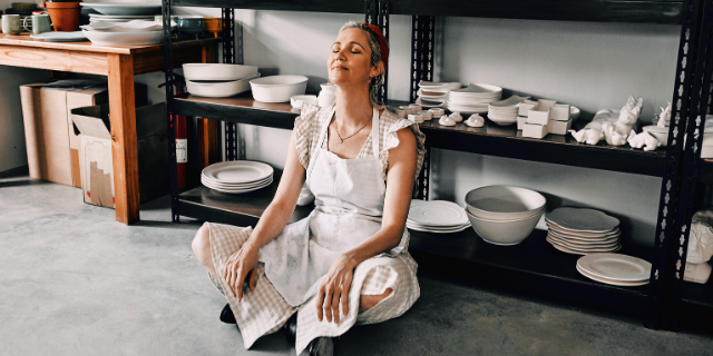 Mulher sentada no chão emanando boas energias