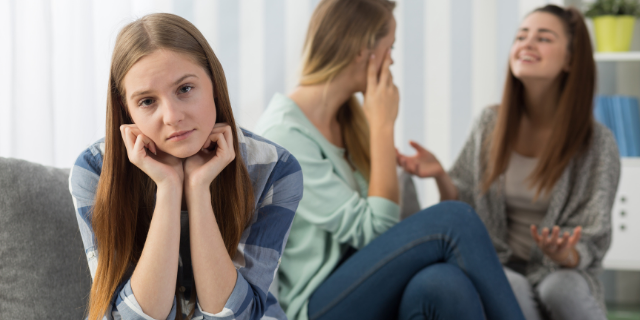 Imagem de menina afastada das amigas