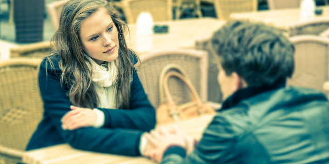 Mulher conversando com homem e segurando sua mão